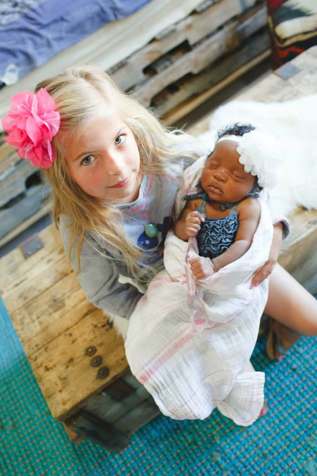 Transracial adoptive sister holding newborn sister