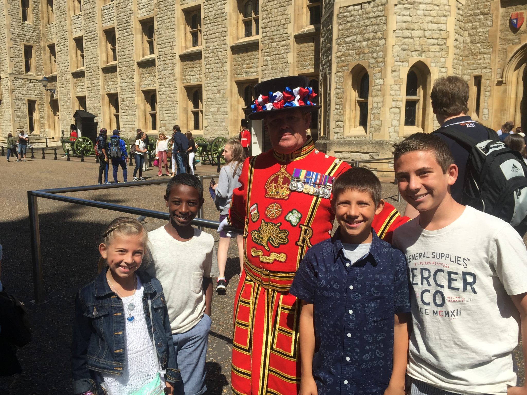 Kids taking a picture with the guards at the Tower of London. Guards in their special uniforms | London with Kids | Global Munchkins