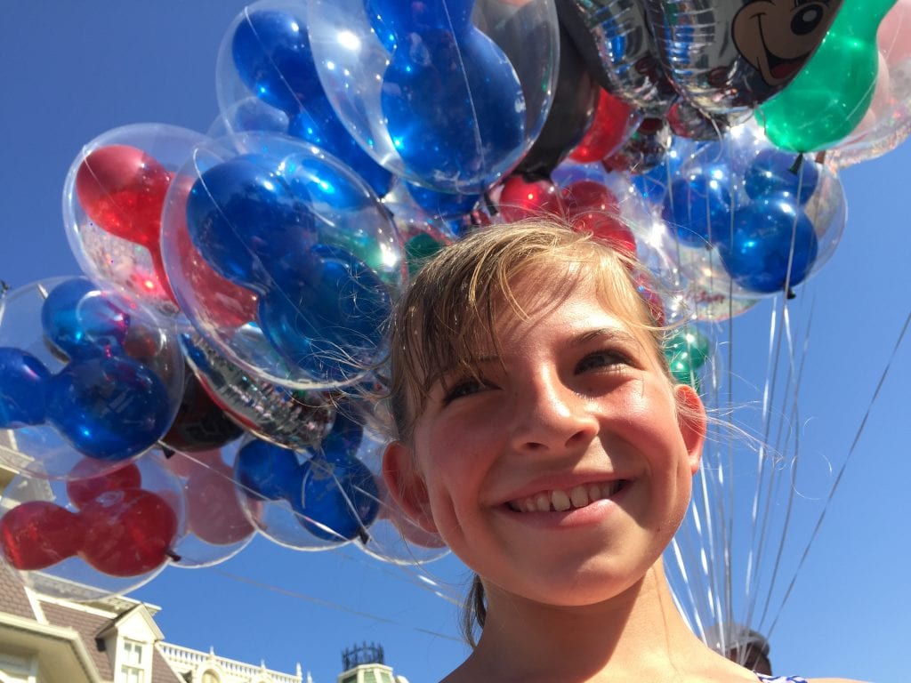 Disney World Tips - Happy Girl with Mickey Balloon Background at Magic Kingdom | Global Munchkins