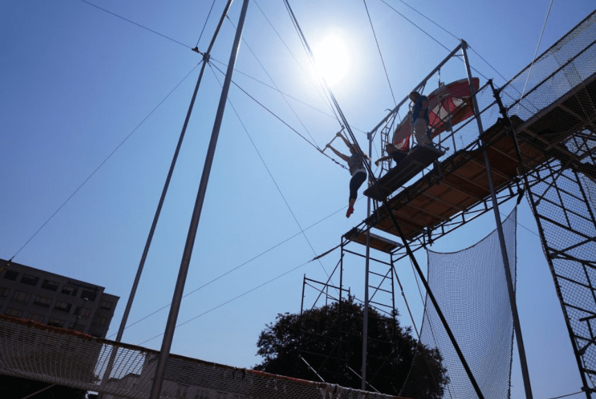 Woman swinging on a trapeze during a lesson at SwingIt Trapeze in Anaheim CA | Global Munchkins